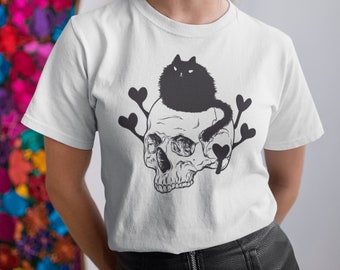 May include: White t-shirt with a black cat sitting on a skull with hearts around it.