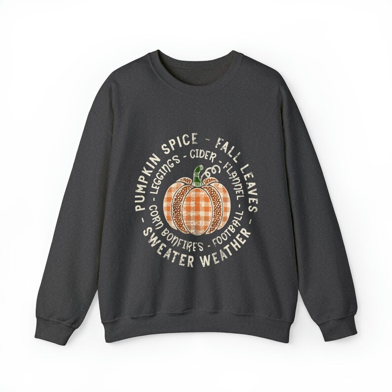 May include: A dark grey sweatshirt with a white circle graphic featuring a pumpkin with a plaid pattern and the text "Pumpkin Spice - Fall Leaves - Leggings - Cider - Flannel - Corn - Bonfires - Football - Sweater Weather".