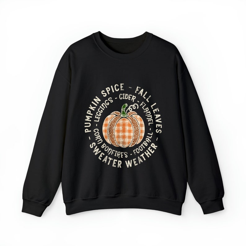 May include: Black sweatshirt with a white circle graphic featuring a pumpkin with a plaid pattern and the text "Pumpkin Spice - Leggings - Cider - Fall Leaves - Corn - Bonfires - Flannel - Football - Sweater Weather".