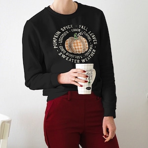 May include: Black sweatshirt with a pumpkin graphic and the text "Pumpkin Spice - Cider - Fall Leaves - Leggings - Flannel - Corn Bonfires - Football - Sweater Weather".