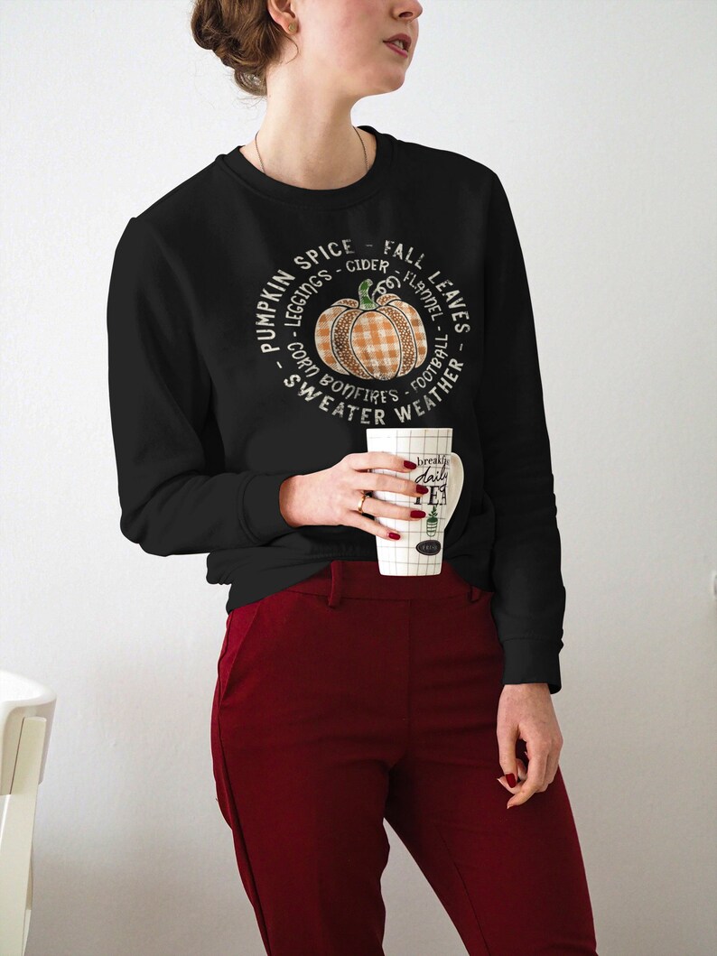May include: Black sweatshirt with a pumpkin graphic and the text "Pumpkin Spice - Cider - Fall Leaves - Leggings - Flannel - Corn Bonfires - Football - Sweater Weather".