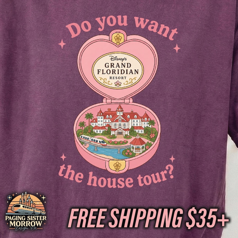 Puede incluir: Una camiseta de color morado oscuro con un gr&aacute;fico de un relicario rosa en forma de coraz&oacute;n. Dentro hay una ilustraci&oacute;n del Grand Floridian Resort con un monorra&iacute;l. El texto dice: Do you want the house tour? y Grand Floridian Resort.