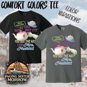 May include: Two Comfort Colors t-shirts, one black and one gray, featuring a cartoon teapot, hat, and text that reads "Ohhh Hannahh! DON'T YOU GET IT? YOU SEE THE HAT? I AM Mrs. Nesbitt!" The shirts have a crew neck.
