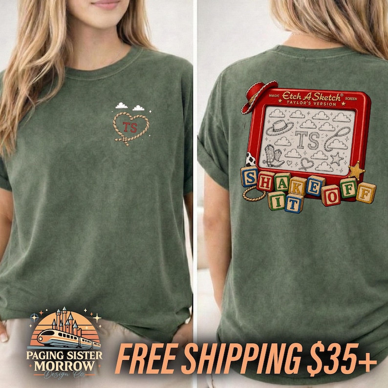 以下が含まれることがあります： ミネラルウォッシュ加工のオリーブグリーンのTシャツ。左胸にはロープで描かれたハートとTSの文字がプリントされています。背面には赤いお絵かきボードの枠の中にEtch A Sketch Taylor's Version、SHAKE IT OFFの文字とアイコンが描かれています。