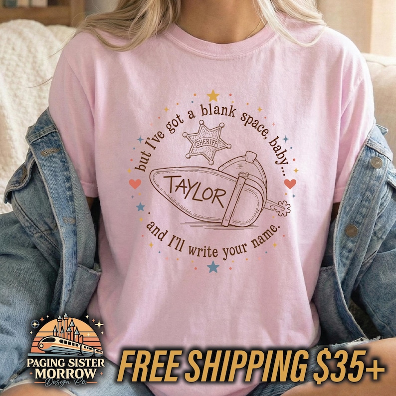 Peut inclure: Un t-shirt rose clair avec une impression graphique marron repr&eacute;sentant une botte de cow-boy et une &eacute;toile de sh&eacute;rif. Le texte indique, but I've got a blank space, baby... and I'll write your name. Le mot TAYLOR est imprim&eacute; sur la botte.