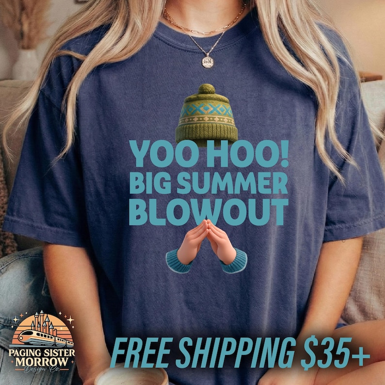 May include: Navy blue t-shirt with the text "YOO HOO! BIG SUMMER BLOWOUT" in turquoise. The shirt features a green hat graphic and cartoon hands. The shirt is from Paging Sister Morrow Design Co.