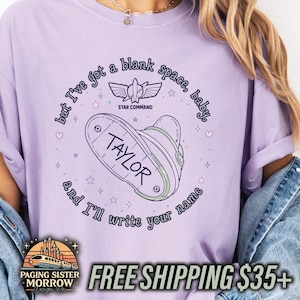May include: A light purple t-shirt featuring a graphic of a space ranger boot with the name TAYLOR printed on it. The design includes the text but I've got a blank space, baby, and I'll write your name, a Star Command logo, and small stars and hearts.