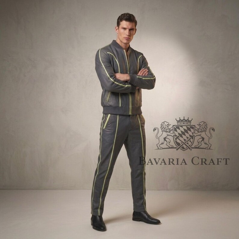 Puede incluir: Chaqueta bomber de cuero gris y pantal&oacute;n a juego con ribetes amarillos. La chaqueta tiene cierre de cremallera y el pantal&oacute;n tiene un dise&ntilde;o de pierna recta. El conjunto se lleva con zapatos de cuero negro. El logotipo de Bavaria Craft es visible.