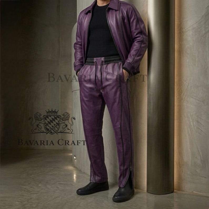 May include: A two-piece purple leather outfit, including a jacket and pants. The jacket has a collar and zipper, and the pants have a drawstring waist and zippers at the ankles. The outfit is paired with black shoes. The brand name "Bavaria Craft" is visible.