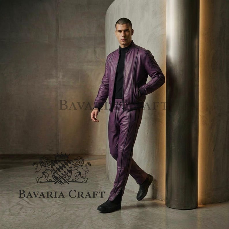 May include: A purple leather bomber jacket and matching pants. The jacket has a zip closure and side pockets. The pants have a straight leg design with a vertical seam. The outfit is worn with a black turtleneck and black shoes. The brand name "BAVARIA CRAFT" is visible.