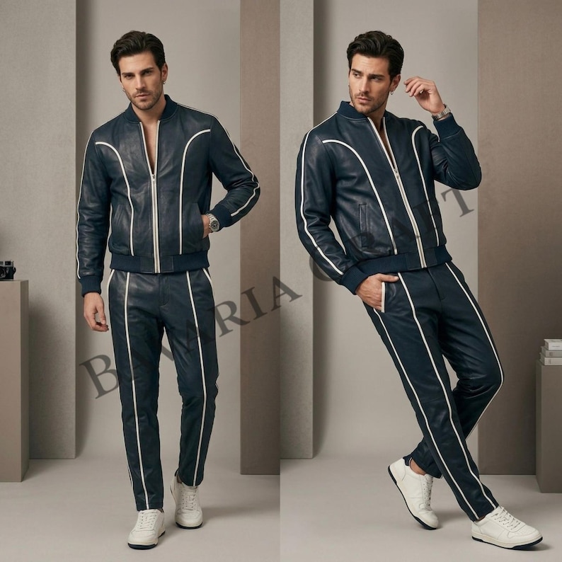 May include: Navy blue leather tracksuit with white piping. The jacket has a zip closure and the trousers have a straight leg design. The tracksuit is paired with white trainers. The overall style is modern and sporty.