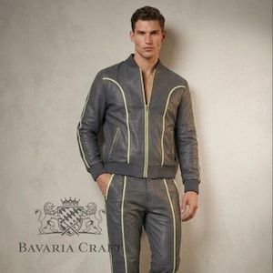 Puede incluir: Chaqueta bomber y pantal&oacute;n a juego de cuero gris con ribete amarillo ne&oacute;n. La chaqueta tiene cierre de cremallera y pu&ntilde;os y dobladillo de canal&eacute;. El pantal&oacute;n tiene cintura con cord&oacute;n. El logotipo de Bavaria Craft es visible en la esquina inferior izquierda.