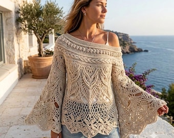 May include: A beige crochet long-sleeve top featuring an intricate openwork pattern, a wide boat neckline, and flared bell sleeves. The garment is crafted with detailed cable-knit textures and floral-inspired motifs throughout the bodice and sleeves.