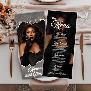 May include: Two black menu cards with a woman's image, set on a table with a fork and knife. The menu cards have the text "The Menu" and "Amara's 25th Birthday". The menu lists starters, main courses, desserts, and drinks.