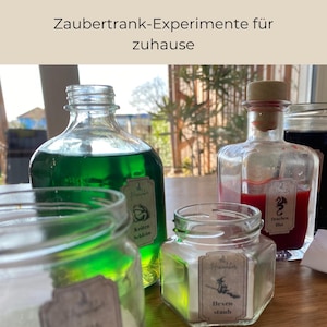 Könnte beinhalten: Eine Sammlung von Glasflaschen und Gläsern, gefüllt mit bunten Flüssigkeiten und Pulvern, beschriftet mit deutschem Text. Das Bild zeigt eine grüne Flüssigkeit, eine rote Flüssigkeit und weißes Pulver, was auf ein Thema der Zaubertrankherstellung hindeutet. Der Text "Das kleine Hexenlabor" steht oben.