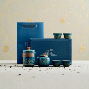 Peut inclure: Un service &agrave; th&eacute; turquoise avec des d&eacute;tails dor&eacute;s, comprenant une th&eacute;i&egrave;re, un petit r&eacute;cipient et des tasses, pr&eacute;sent&eacute; avec une bo&icirc;te et un sac cadeaux bleus. L'ensemble a un design traditionnel.