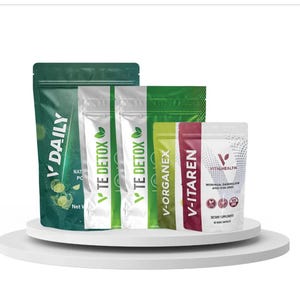 May include: Assortment of supplement pouches in green, white, and red. The pouches are labeled with text including "V DAILY", "TE DETOX", "V-ORGANEX", "V-ITAREN", and "VITALHEALTH". The products are displayed on a white, circular platform.