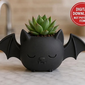 May include: A matte black bat-shaped planter featuring a sleeping face with small fangs and outstretched wings. A green succulent is planted inside the container. A red circular badge in the corner contains the text DIGITAL DOWNLOAD NOT PHYSICAL ITEM.