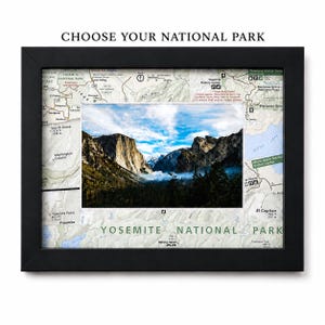 May include: A black framed wall art piece featuring a central color photograph of Yosemite National Park mountains and forest, surrounded by a detailed topographic map of the area. The text CHOOSE YOUR NATIONAL PARK is at the top.