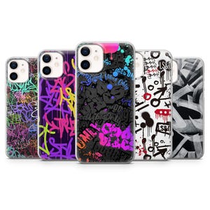 May include: A collection of five phone cases with graffiti art designs. The cases feature vibrant colors, including pink, purple, green, and black, with various text and abstract patterns. The cases are designed for a smartphone.