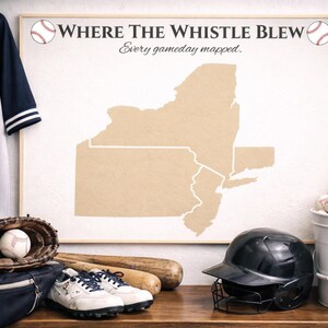 May include: Baseball-themed display featuring a jersey with the number 7, a baseball glove with a ball, a map of New York, and baseball equipment. The map is framed and has the text "Where The Whistle Blew". A black helmet and baseballs are also present.