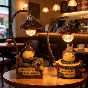 Puede incluir: Dos lámparas decorativas con un diseño de personaje de dibujos animados. Cada lámpara tiene una pantalla marrón, un brazo curvo y una bombilla. La base de cada lámpara presenta el personaje de dibujos animados y texto. Uno dice "Like You've Been Around" y el otro dice "Every night with you."