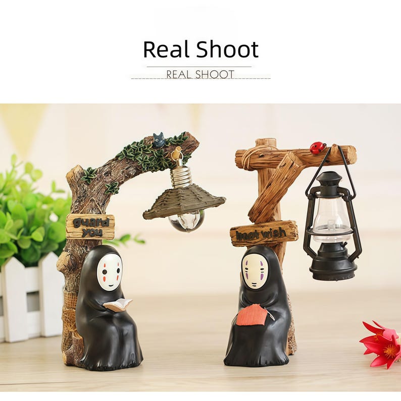 May include: Two decorative figurines featuring characters from a popular animated film. One holds a book under a lamp, the other knits under a lantern. The text "Real Shoot" is at the top.