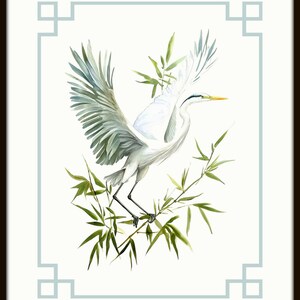 May include: Watercolor painting of a white heron with outstretched wings, perched on green bamboo branches. The bird has a yellow beak and gray-green wing feathers. The artwork is framed with a light blue border and a dark brown frame.