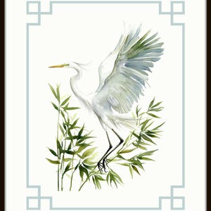 May include: Watercolor painting of a white egret with outstretched wings, perched among green bamboo stalks. The artwork is framed with a light blue border and a dark brown frame, creating a serene and natural aesthetic.