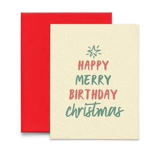 May include: A cream-colored card with the text "Happy Merry Birthday Christmas" in green and pink lettering. The card has a red envelope.