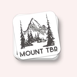 Może przedstawiać: Czarno-biała ilustracja pasma górskiego z drzewami z przodu. Tekst "MOUNT TBR" znajduje się pod obrazem.