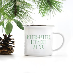 May include: White enamel camping mug with a green inscription that reads "Pitter-Patter Let's Get At 'er."