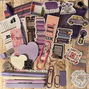 May include: A collection of purple and pink stationery and stickers, including pens, paperclips, bookmarks, and heart-shaped cutouts. The items feature book-themed designs and phrases like "In My Smut Era" and "Smutty Book Club."