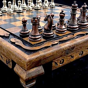 Könnte beinhalten: Ein Schachspiel aus Holz mit einem Brett aus abwechselnd hellen und dunklen Feldern. Eine Seite hat metallisch silberne Schachfiguren, während die andere Seite dunkel bronzefarbene Figuren aufweist. Das Brett hat einen geschnitzten Holzrahmen.