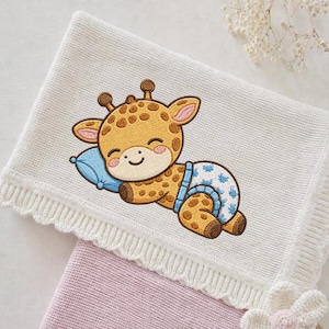 May include: A white baby blanket with a crocheted edge and a smiling giraffe embroidery. The giraffe is wearing a diaper and resting its head on a blue pillow. A pink blanket is visible underneath.