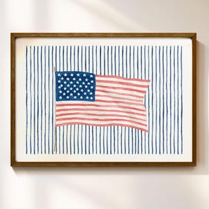 Pode incluir: Uma impressão em aguarela emoldurada apresentando uma bandeira americana horizontal com riscas vermelhas e brancas e um cantão azul com estrelas brancas. A bandeira está centrada num fundo de riscas verticais azuis finas.