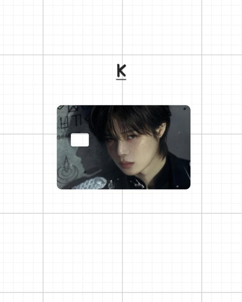 May include: A rectangular card featuring a portrait of a person with dark hair and a black top. The card has a white rectangle and some text on the left side. The letter "K" is above the card.