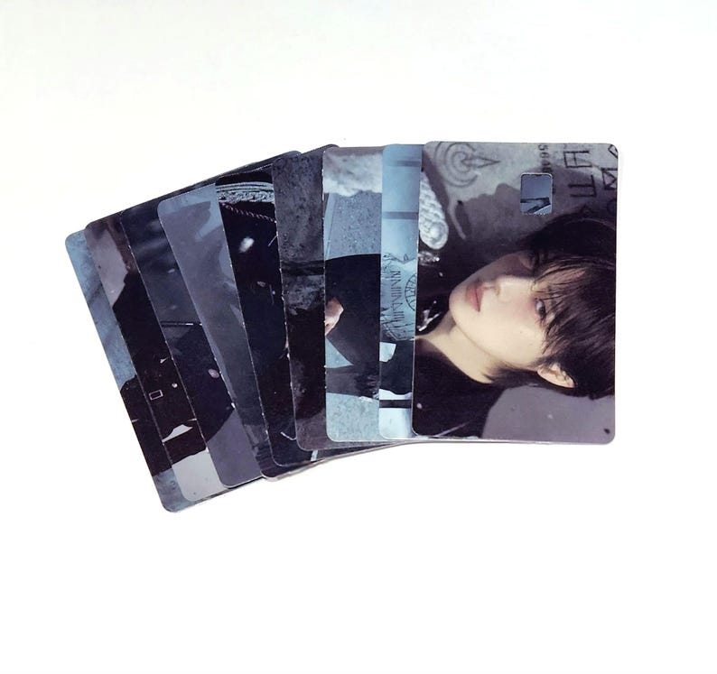 May include: A fan of rectangular cards with images of a person in various poses. The cards have a cool color palette of blues and grays. The cards are fanned out, revealing the different images.