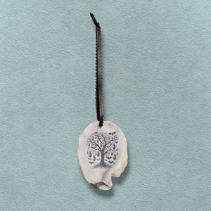 May include: A pendant with a black cord and a white, irregular-shaped charm. The charm features a tree design with colourful ornaments and bats. The pendant is likely handmade and suitable for Halloween or gothic-themed jewellery.