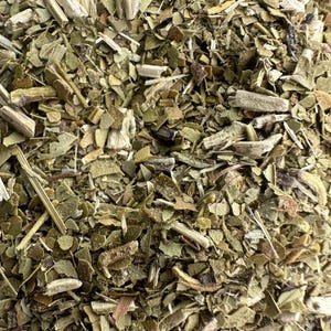 May include: A collection of dried yerba mate leaves, stems, and small twigs. The mixture features a variety of textures and shades of green, ranging from light olive to deep forest green, interspersed with light tan and woody brown fragments.