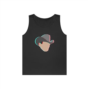 May include: Black tank top featuring a stylized graphic of a cowboy hat and face with a 3D effect. The hat is gray with red and blue accents, and the face is a light tan color. The design is centered on the front of the tank top.