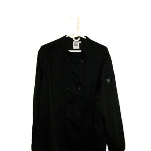 May include: Black chef jacket with a double-breasted closure and a patch on the left sleeve that says "Chef's Choice".