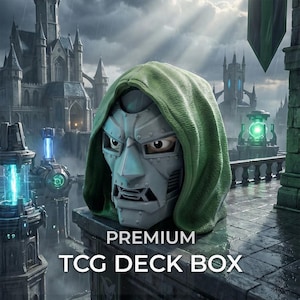 Op de afbeelding: Een premium TCG-deckbox in de vorm van een metallic zilveren masker met een groene capuchon. Het masker heeft een geklonken ontwerp en een strenge uitdrukking. De tekst PREMIUM TCG DECK BOX staat in witte hoofdletters onderaan de afbeelding.