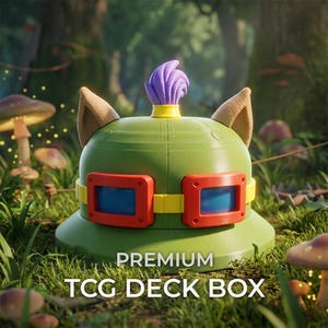 Puede incluir: Una caja para barajas TCG de color verde con un mechón morado en la parte superior, dos orejas de color tostado y un par de gafas azules con montura roja y correa amarilla. El texto PREMIUM TCG DECK BOX está impreso en blanco abajo.