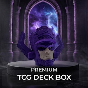May include: A purple TCG deck box shaped like the head of a character with a prominent helmet, featuring a face with a serious expression. The text PREMIUM TCG DECK BOX is printed in white on the front of the base supporting the object.