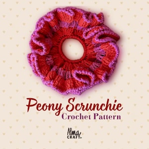 Puede incluir: Un coletero de ganchillo redondo y con volantes que presenta bandas alternas de hilo rojo vibrante y rosa brillante. El texto debajo dice Peony Scrunchie Crochet Pattern y Alma CRAFT. El fondo es de color crema con pequeños iconos de corazones.