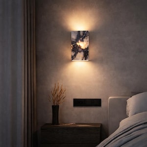 May include: A white ceramic mug with a black handle and the text "But First, Coffee" in a bold, black font. The mug is set against a blurred background, suggesting a cozy setting.