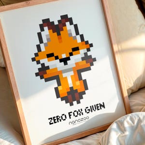 May include: A framed print featuring a pixelated orange fox with a white chest and black accents. The artwork includes the text "ZERO FOX GIVEN" in bold, black letters, and the name "nanozoo" below. The frame is a light brown color.