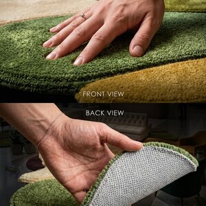 May include: Close-up of a multi-colored rug with a circular design. The rug features shades of green, gold, purple, and beige. The image shows both the front and back of the rug, highlighting its texture and construction. The text "FRONT VIEW" and "BACK VIEW" are visible.