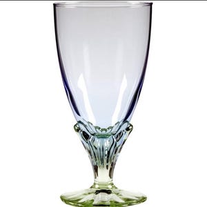May include: A clear, stemmed water glass with a light blue tint. The base and stem are a pale green color, with a decorative, floral-like design at the base of the bowl. The glass has a wide bowl and a slender stem.